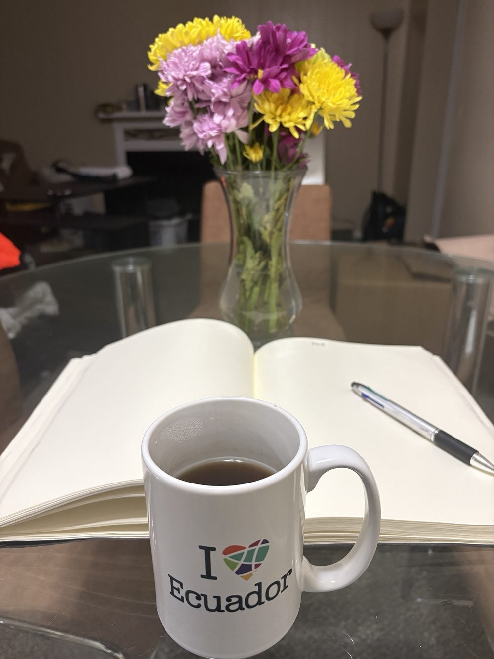 Taza de café servida junto a un cuaderno abierto